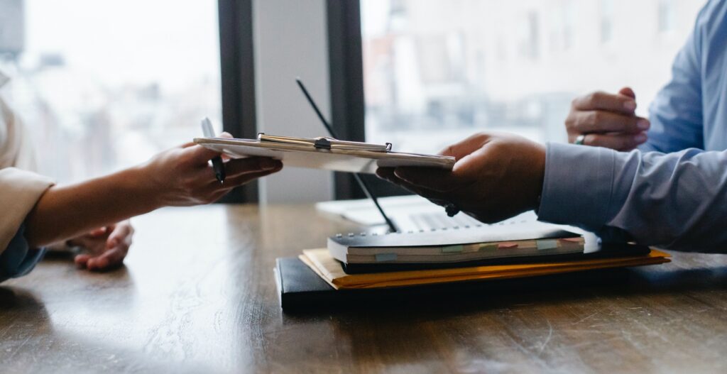 a picture of a man handing a paper to a woman as in giving her a promotion.